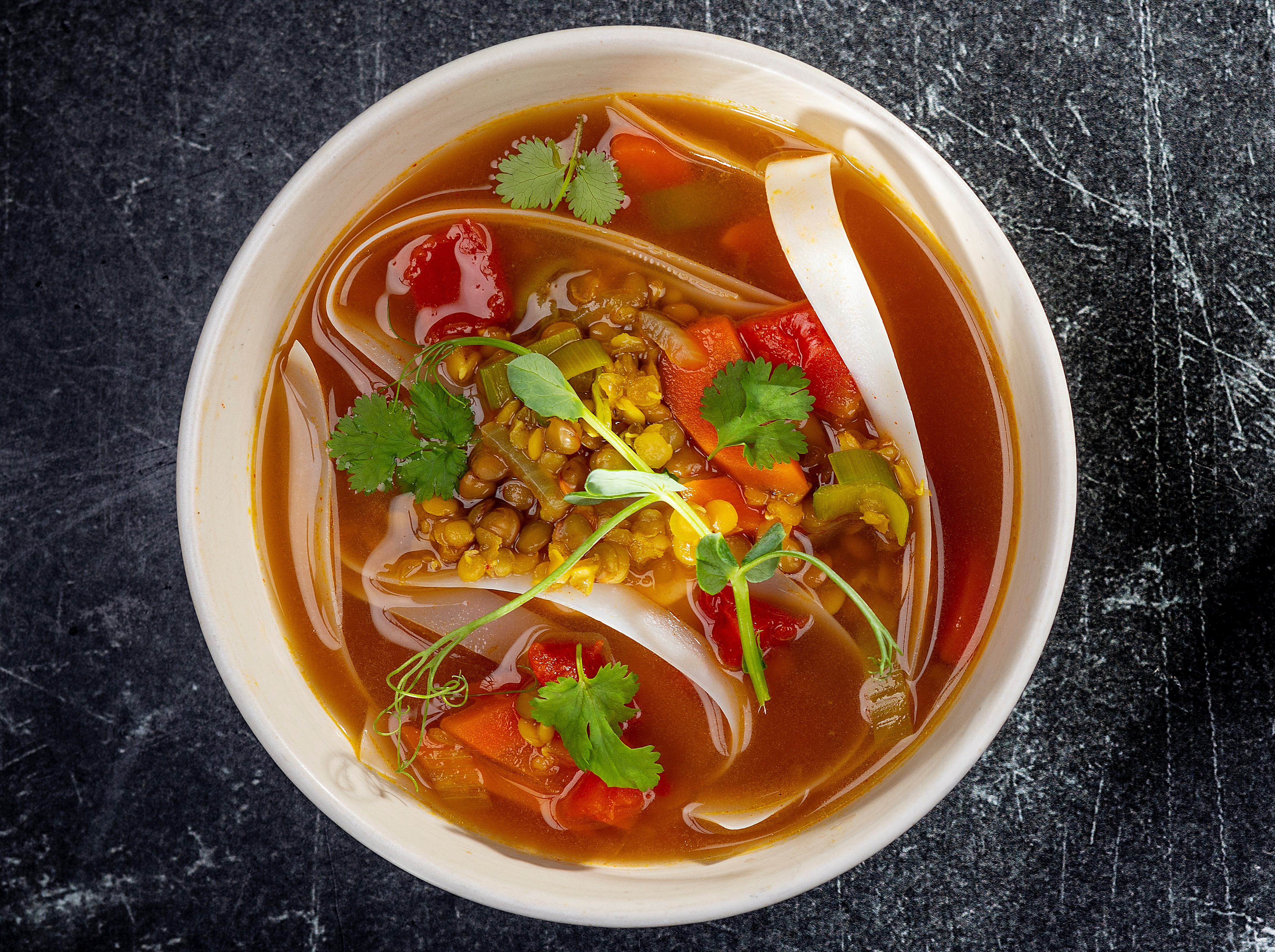 VEGANIŠKA LĘŠIŲ SRIUBA SU RYŽIŲ MAKARONAIS, AŠTRIAISIAIS ČILI PIPIRAIS IR KALENDRA